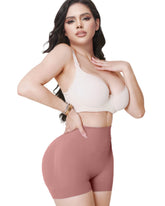 Woman wearing a white sports bra and pink shorts on a light background