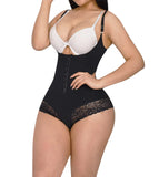 Woman wearing a black shapewear bodysuit with white bra on a white background