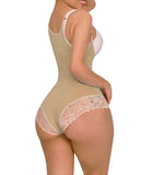 Woman wearing a beige shapewear garment with lace details on a white background