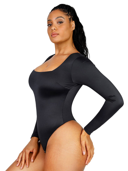 Woman wearing a black long-sleeve bodysuit against a plain background