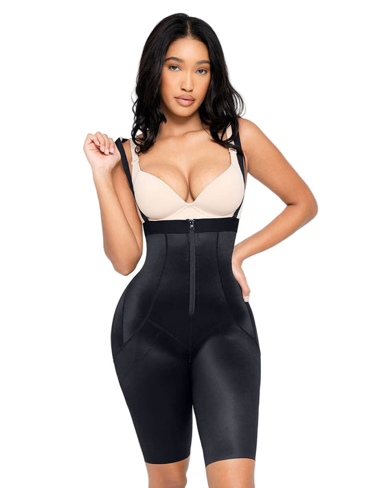 Woman wearing a black shapewear garment over a beige top on a white background