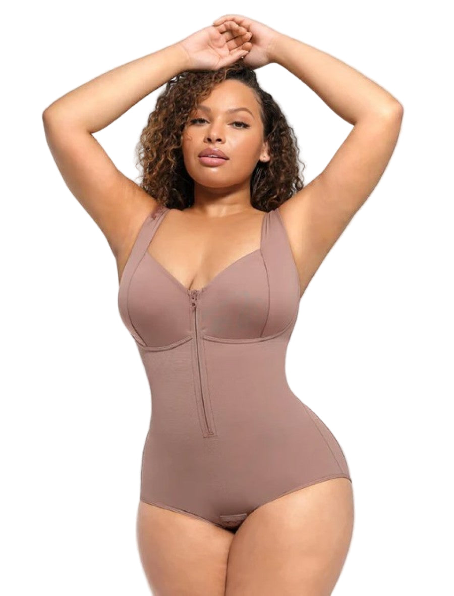 Woman wearing a brown bodysuit against a light gray background