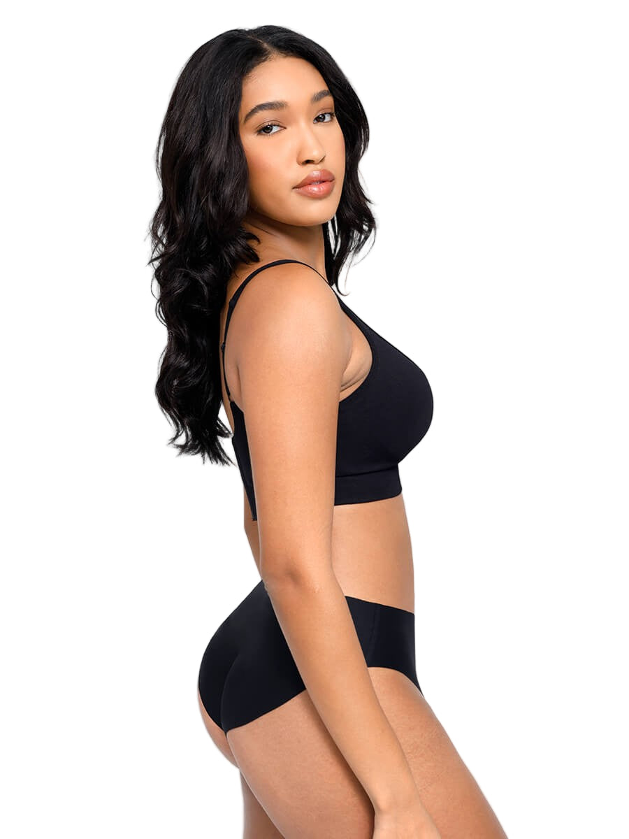 Woman wearing a black bra and underwear set on a plain background