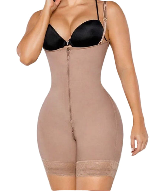 Woman wearing a beige shapewear garment over a black bra on a plain background