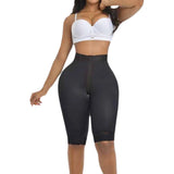 Person wearing a black shapewear garment on a plain background