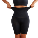 Person wearing black shapewear shorts against a white background