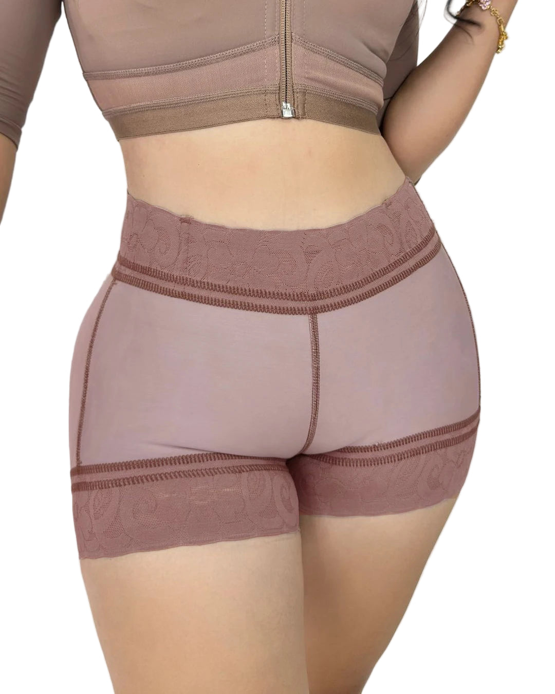 Person wearing a brown sports bra and shorts set on a plain background
