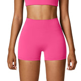 Person wearing bright pink athletic shorts on a plain background