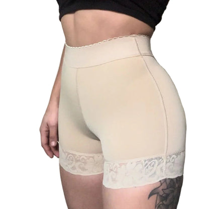 Beige shapewear with lace details worn by a person against a neutral background