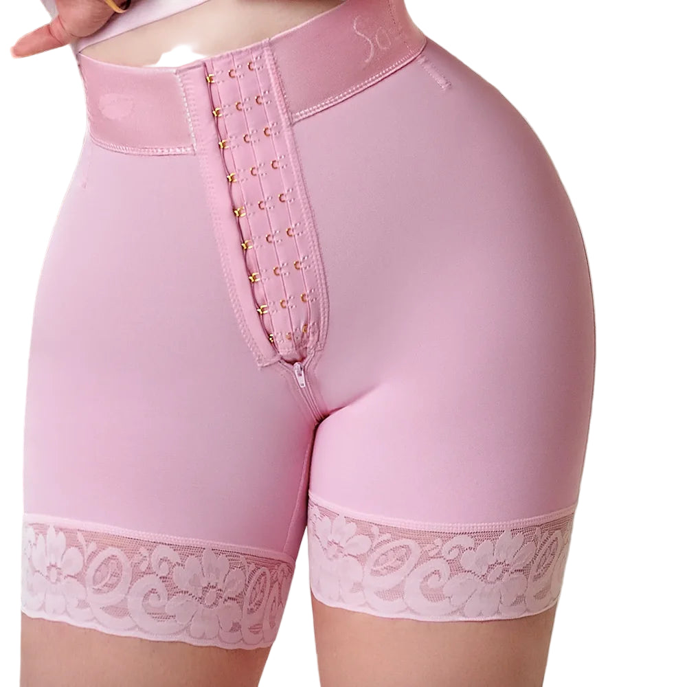Pink shapewear shorts with lace trim on a neutral background