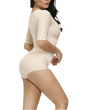 Woman wearing a beige shapewear bodysuit on a white background