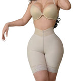 Person wearing a beige shapewear garment in an indoor setting.