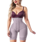 Woman wearing a purple bra and gray waist trainer on a white background