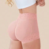 Pink high-waisted underwear with lace trim on a beige background