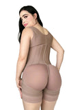 Woman wearing a beige shapewear bodysuit in a bedroom setting.