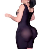 Person wearing a black bodysuit with sheer panels against a plain background