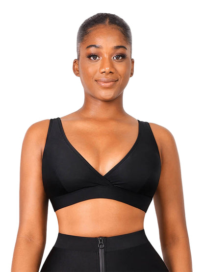 Woman wearing a black sports bra and leggings on a white background