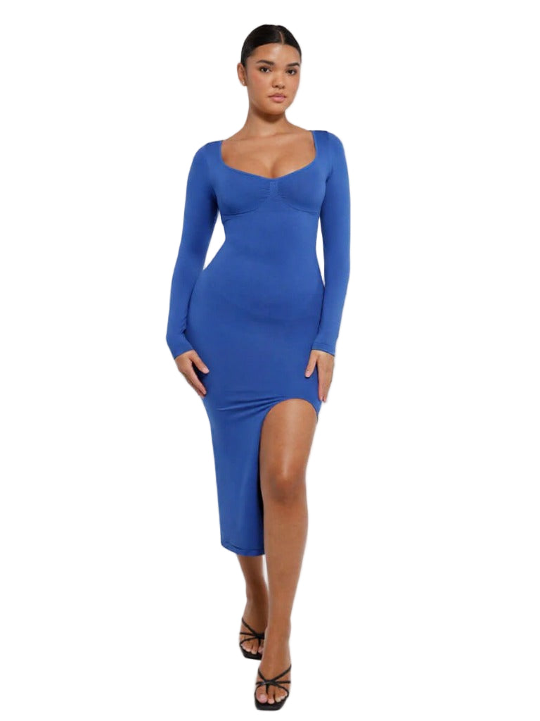 Woman wearing a blue dress with long sleeves and a slit on a white background